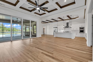 Unfurnished living room with coffered ceiling, lig