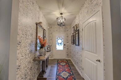 Welcoming entry with notable chandelier and wood f