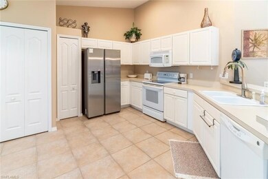 Kitchen featuring white cabinets, light tile patte