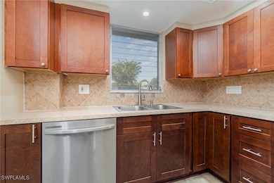 Kitchen featuring sink, backsplash, and dishwasher
