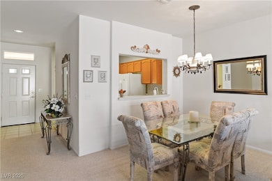 Dining area with light carpet, and a chandelier