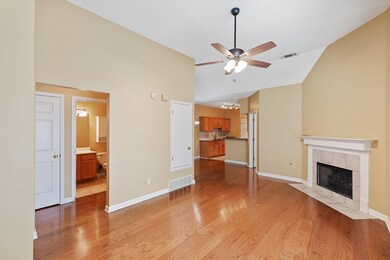 Large room with a tile fireplace, ceiling fan, vau