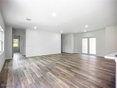 Unfurnished room featuring french doors, wood fini