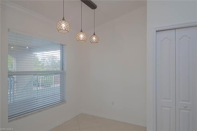 Empty room featuring ornamental molding, light tile patterned flooring, and baseboards