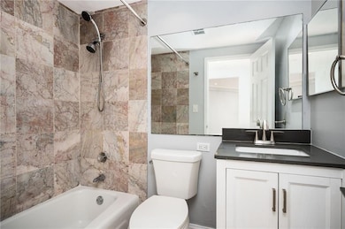 Bathroom with shower / tub combination,  tile surround and Stone vanity
