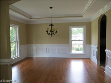Dining Room. Formal Dining with Tray Ceiling, Arched Doorways & Wainscoating