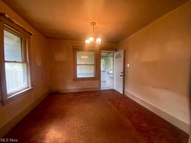 Carpeted living room featuring a notable chandelie