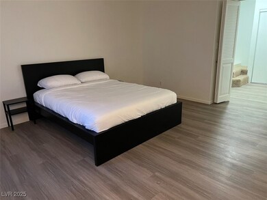 Bedroom with wood finished floors and baseboards