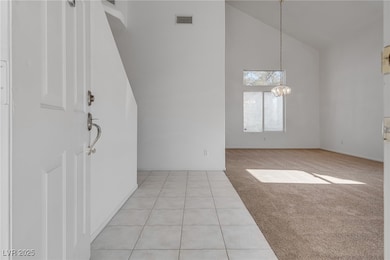 Foyer entrance featuring light colored carpet, lig