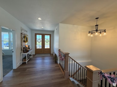 Foyer featuring a chandelier, recessed lighting, wood finished floors, french doors, and a textured ceiling