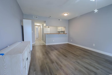Unfurnished living room featuring wood finished floors and baseboards