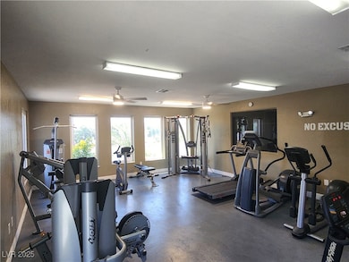 Exercise room with baseboards and a ceiling fan