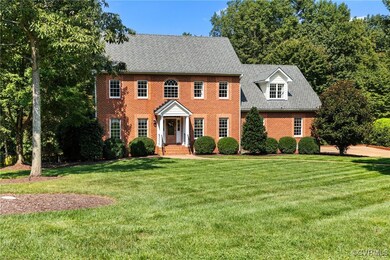 Colonial-style house featuring meticulously manicu