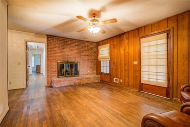 Unfurnished living room featuring wooden walls, ce