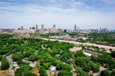 Drone / aerial view of city skyline and a tree filled landscape