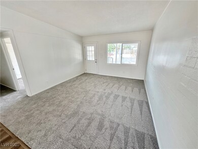 Empty room featuring lofted ceiling and carpet