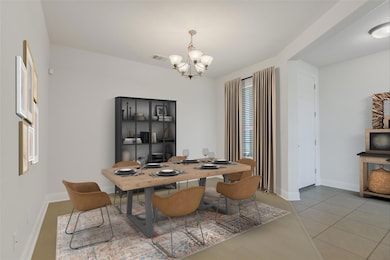 Dining room featuring a chandelier and baseboards