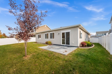 Back of house featuring a large, fenced yard and patio,