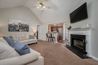 VAULTED CEILINGS AND A WOOD-BURNING FIREPLACE COMPLETE THIS COZY LIVING ROOM.