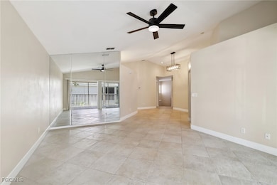 Living room featuring vaulted ceiling, a ceiling fan, and light tile patterned floors