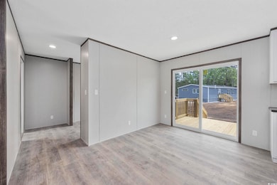 Empty room featuring light wood-type flooring and recessed lighting