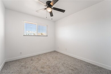 Empty room featuring a ceiling fan, carpet, and ba