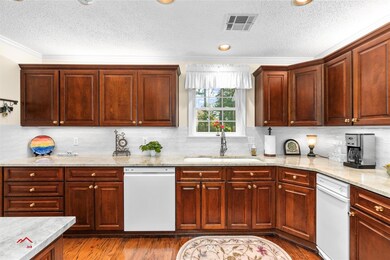 Kitchen featuring dishwasher, sink, backsplash, an