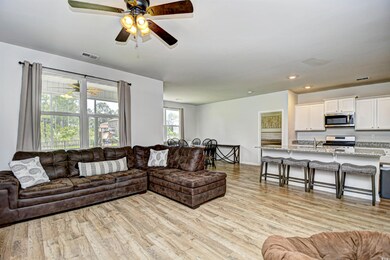 Living room featuring light wood-type flooring, a ceiling fan, recessed lighting, and baseboards