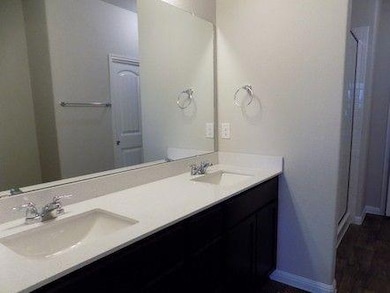 Full bath featuring double vanity and baseboards