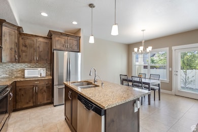 Kitchen featuring dark brown cabinetry, light stone countertops, stainless steel appliances, tasteful backsplash, and a textured ceiling