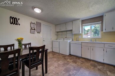 Kitchen featuring washer and dryer, white cabinetr