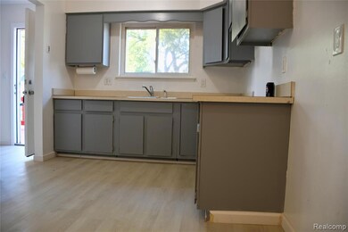Kitchen featuring gray cabinets, light countertops, and light wood finished floors