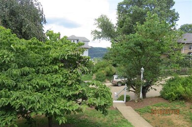 Between the house acroos the street and  the green