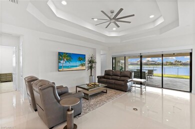Living area featuring a tray ceiling, ceiling fan, recessed lighting, and tile patterned flooring