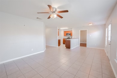 Unfurnished living room with light tile patterned flooring and ceiling fan