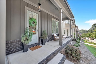 View of exterior entry featuring covered porch and board and batten siding