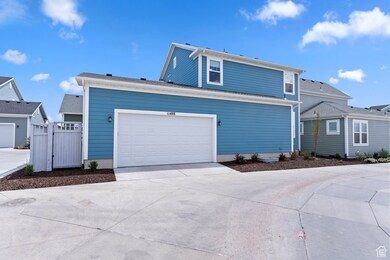 View of front facade with driveway, an attached garage, and a gate
