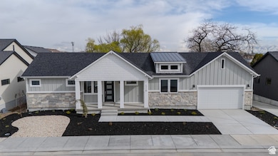 Modern farmhouse style home featuring board and batten siding, stone siding, and a shingled roof