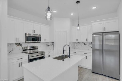 Kitchen with white cabinetry, sink, stainless stee