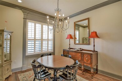 Dining room with a notable chandelier, dark hardwood / wood-style flooring, and crown molding