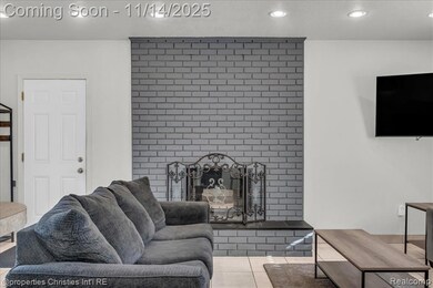 Living room with recessed lighting, light tile patterned floors, and a brick fireplace