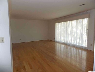 Huge formal living room with bay picture window and hardwood flooring.