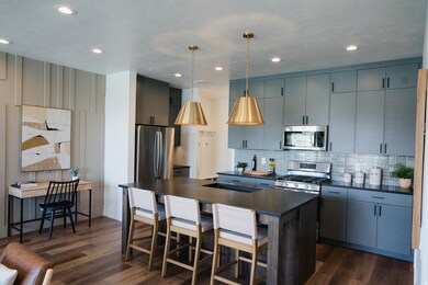 Kitchen with a kitchen bar, a center island, appliances with stainless steel finishes, dark wood finished floors, and recessed lighting