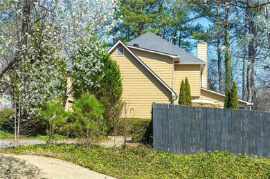 View of property exterior with fence, a chimney, and a shingled roof