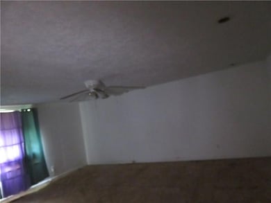 Unfurnished room featuring carpet floors and ceiling fan