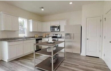 Kitchen featuring white cabinets, light wood-type flooring, and stainless steel appliances