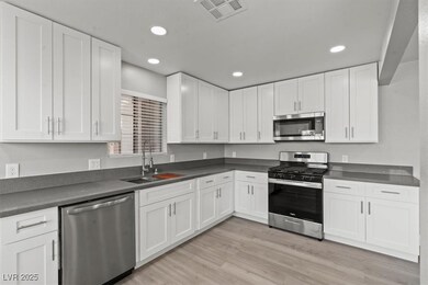 Kitchen with a sink, light wood finished floors, w