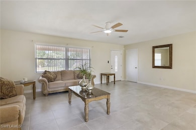 Living room with baseboards, a ceiling fan, and vi