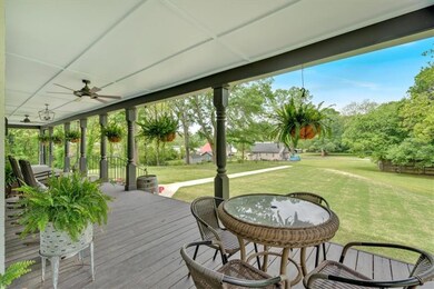 Wooden porch featuring a lawn and ceiling fan