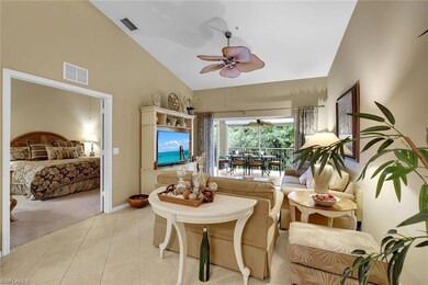 The living room with tile on the diagonal and vaulted ceilings opens up to the spacious lanai, and adjoins the primary bedroom through French doors.